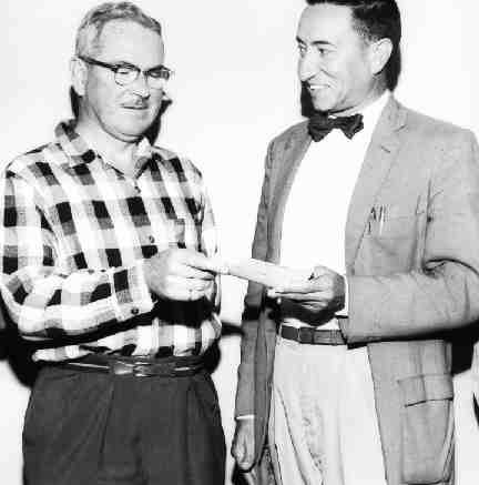 Peter Ribboto, manager of Caland Ore Co., presents the first royalty cheque to M.S. Fotheringham, president of Steep Rock Iron Mines near Atikokan, Ont. Caland Ore leased the "C" property from Steep Rock and began production in 1960.