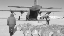 Workers unload fuel and supplies from a Hercules C-130 transport aircraft at the Igloolik Airport.