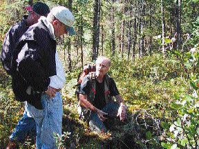 At Rare Earth Metals' Assean Lake project in Manitoba, Director Bob Sibthorpe (left foreground) discusses soil samples with Project Geologist Dan Ziehlke.