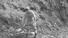 Calvin Keats, a prospector working for Crosshair, pans oxidized subcrop from Titan trench 7.