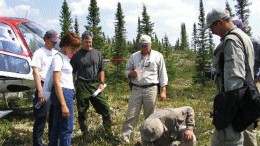 From left: Ashton Project Geologist Alan O'Conner (green pants) and Project Manager Robert Lucas (centre) look on as Pierre Bertrand, vice-president of exploration with Soquem, examines the ground at the Lynx South showing on Ashton's Foxtrot property in north-central Quebec.
