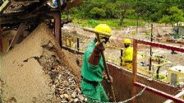 A worker directs ore into the primary crusher at Anvil's Dikulushi processing plant.