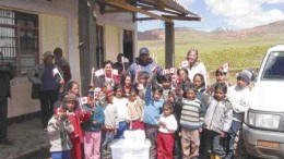 Gitennes Exploration geologists Jorge Zapata and Gayle McCleery donate a set of encyclopedias to school children in Llasca, Peru. Gitennes is exploring the nearby Tucumachay gold project.