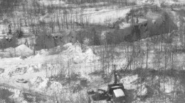 A drill at the Canadian Malartic property of Osisko Exploration operates near a glory hole of the original Canadian Malartic mine.