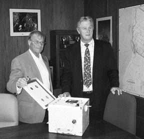 HY-DRIVE TECHNOLOGIESHy-Drive CEO Tom Brown (left) and MTI CEO Bob Lipic sign an agreement whereby mining equipment builder MTI will use Hy-Drive's patented HGS technology in certain diesel and gas-burning vehicles. The Hy-Drive prototype is shown.