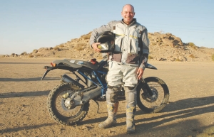 Lukas Lundin, chairman of Lundin Mining, posing in front of his BMW motorbike which he rode from Cairo to Cape Town in 2006 to promote global awareness of critical issues in Africa. Lundin Group has pledged US$100 million to the Clinton-Giustra Sustainable Development Initiative, a program aimed at fighting poverty in developing countries.