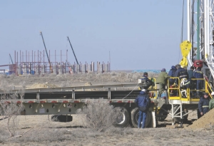 A new drill rig arrives in Kazakhstan, with Uranium One's South Inkai plant in the background.