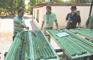 Platinum Group Metals' project manager Andre du Plessis (left), company president and CEO Michael Jones (centre) and London-based investment manager, Hugo Worth, review core at the company's exploration facility in the Bushveld Complex of South Africa.