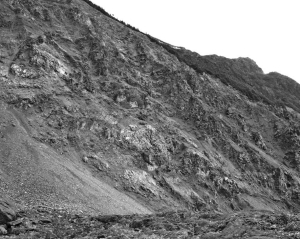 A mineralized cliff face at Romios Gold Resources' Trek property in the Galore Creek area of B. C., 300 km northwest of Smithers. Hole 1 of the cliff-face outcrop intercepted 32 metres grading 2.06% copper, 1.05 grams gold per tonne and 26.01 grams silver starting 148 metres down-hole.