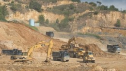 Caterpillar equipment is used to stockpile topsoil at Barrick Gold's Pueblo Viejo gold project in the Dominican Republic. The global economic slowdown has cut into Caterpillar's profits, prompting the company to announce layoffs of nearly 24,000 people.