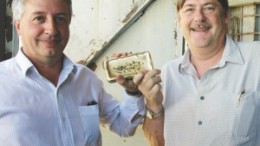 Brent Butler, ATW Gold president and CEO (left), and David Stone, chief operating officer, pose with the company's first gold dor bar from the new Burnakura underground gold mine in Western Australia.
