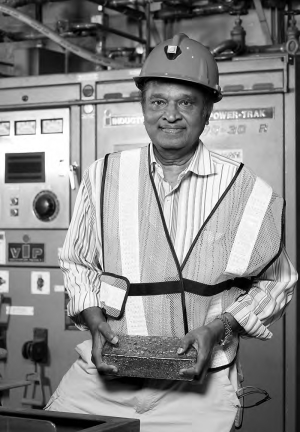 Sethu Raman, a director of Lake Shore Gold, poses with the first gold dor bar from the company's Timmins mine, near Timmins, Ont.