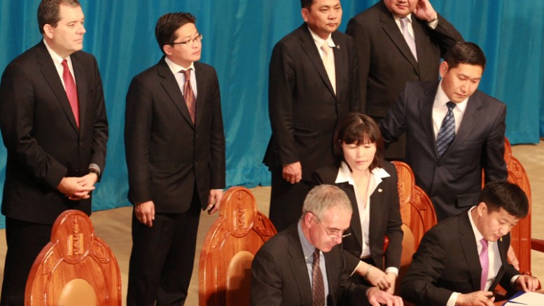 Keith Marshall (sitting, left), managing director of Ivanhoe Mines Mongolia, and Sangajav Bayartsogt (sitting, right), Mongolian Minister of Finance, sign Oyu Tolgoi agreements at a ceremony on Oct. 6, 2009, in the Mongolian State Palace in Ulaanbaatar. Photo credit: Ivanhoe Mines