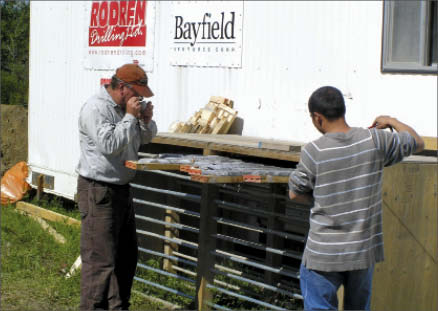 Geologists Bob Marvin (left) and Shane Hu examine core at Bayfield Ventures' Burns Block gold project in northwestern Ontario. Photo by Bayfield Ventures