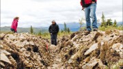 Kaminak Gold VP of exploration Tim Smith (far right) and colleagues explore a trench at the Coffee gold project in the Yukon. Photo by Ian Bickis