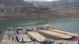 Barges are loaded with ore for transport across the reservoir. Source: Silvercorp Metals