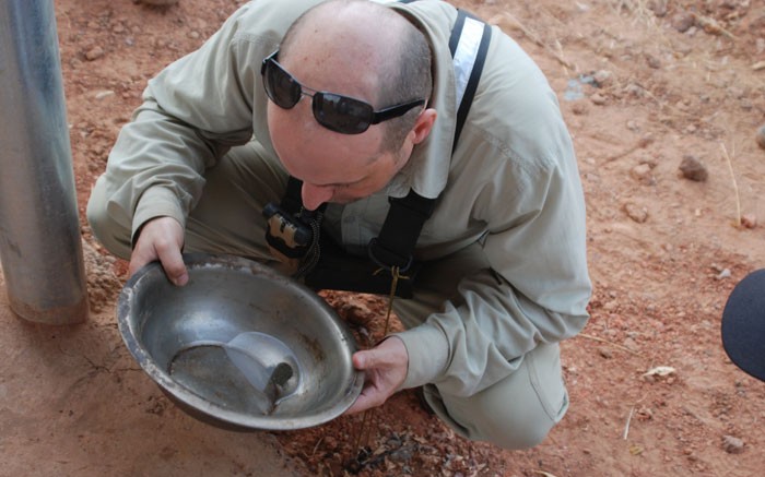 True Gold Mining's vice-president of exploration Scott Heffernan examining sulphide mineral grains panned from reverse circulation samples samples at the Watinoma discovery at the Karma gold project in Burkina Faso.  Source: True Gold Mining