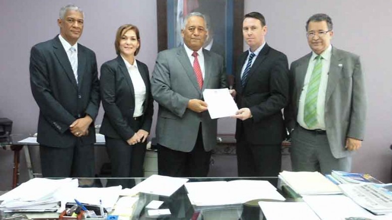 The Dominican Republic's Director of Mining, Alexander Medina (middle), presenting the mineral-exploration permit for the Juan de Herrera gold property to Precipitate Gold CEO Jeffrey Wilson. Credit: Precipitate Gold