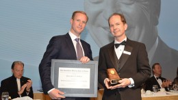 Doug Donnelly (right), Canadian Mining Hall of Fame director and publisher of The Northern Miner, presenting to Gavin McOuat, son of inductee Jack McOuat. Credit:  Canadian Mining Hall of Fame