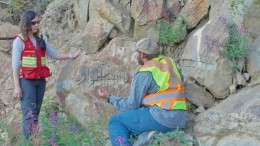 Victoria Gold project geologist Helena Kuikka and Yukon Geological Survey geologist Patrick Sack discuss an outcrop at the Olive zone, part of Victoria's Dublin Gulch gold project in Yukon. Photo by Gwen Preston.