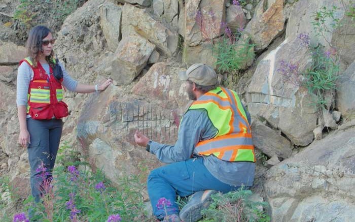 Victoria Gold project geologist Helena Kuikka and Yukon Geological Survey geologist Patrick Sack discuss an outcrop at the Olive zone, part of Victoria's Dublin Gulch gold project in Yukon. Photo by Gwen Preston.