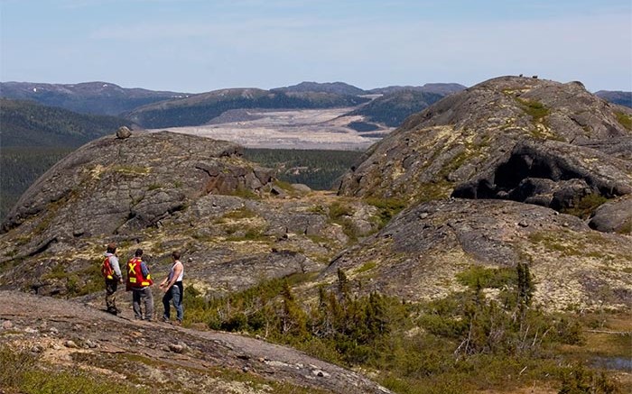 Three geologists look toward the Voisey's Bay  open pit mine. Photo by Joshua Duggan (CC 2.0).