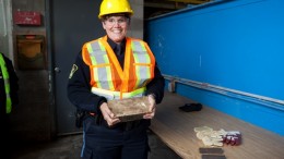 An Ontario Provincial Police officer poses with a freshly poured gold bar at the Mishi gold mine opening in Ontario in 2012. Credit: Wesdome Gold Mines