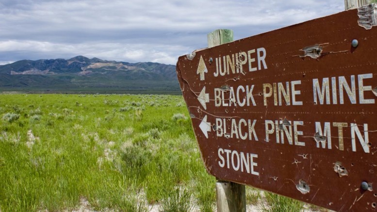 An old sign in southeast Idaho points to the Mineral Gulch gold project, seen in the distance. Credit: Northern Miner Staff.