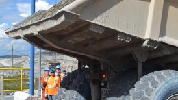 Workers look on as a truck prepares to dump the first load of ore into the primary crusher at Stornoway Diamond’s Renard diamond mine in Quebec. Credit: Stornoway Diamond.