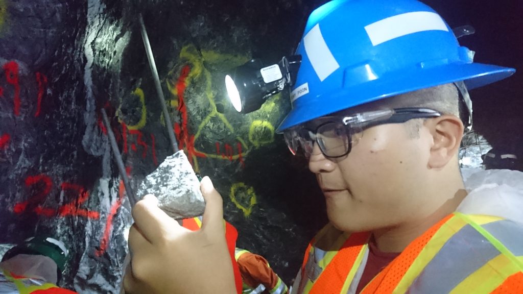 Jeremy Poon, associate with Raymond James, examines a piece of ore underground at Island Gold. Photo by Richard Quarisa.