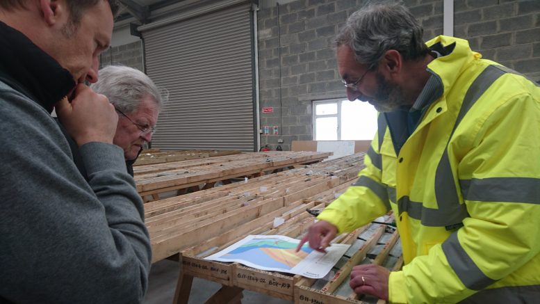 Dr. Mark Holdstock (right) at Group Eleven's core shack discusses Ballinalack's geology with company CEO Bart Jaworski (left) and writer Bob Moriarty (center). Photo by Richard Quarisa.