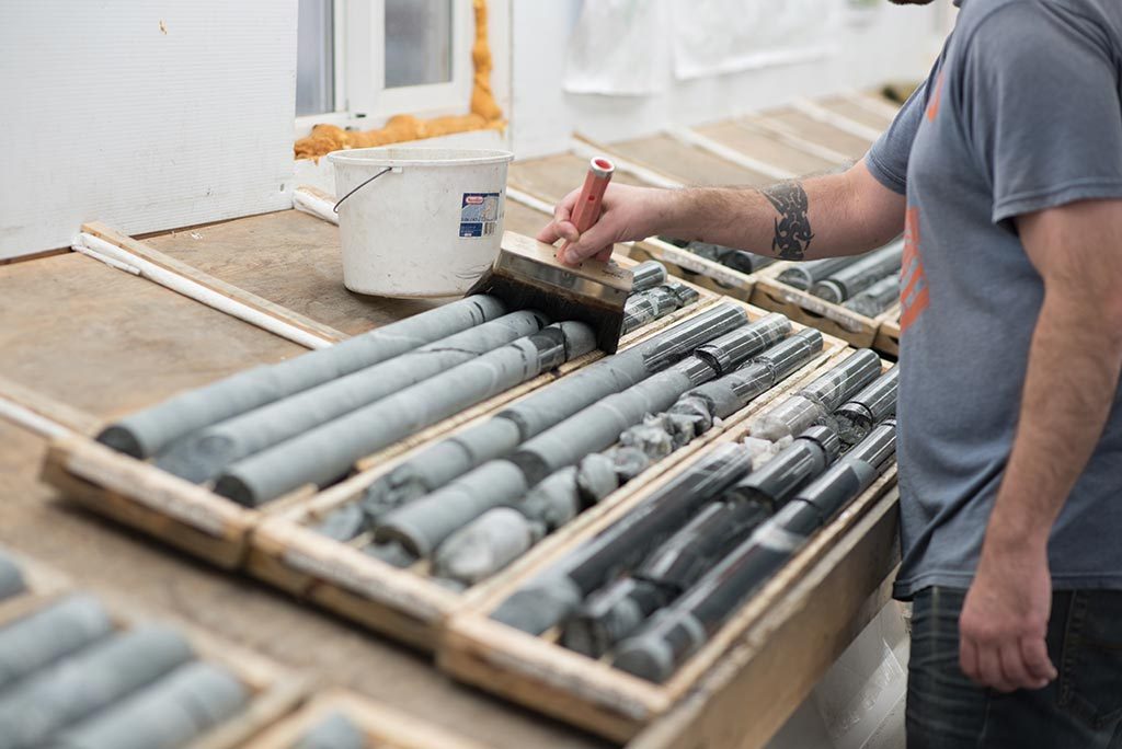 A worker wets drill core from the Colomac deposit at Nighthawk Gold’s Indin Lake gold project. Credit: Nighthawk Gold.