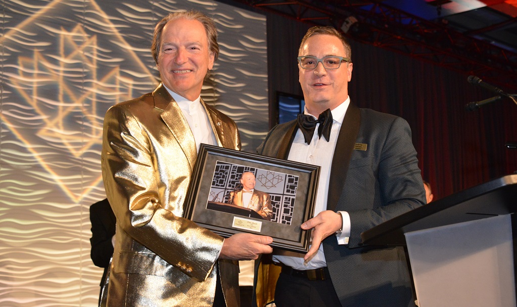 Northern Miner Group publisher Anthony Vaccaro (left) present Franco-Nevada chairman Pierre Lassonde with a memento to honour his serving as master of ceremonies at the Canadian Mining Hall of Fame’s induction ceremony for the past 18 years. Lassonde was inducted into the CMHF in 2013. Going forward, Vaccaro will take up the MCing duties at the annual CMHF induction ceremony. Photo Credit: Keith Houghton Photography.