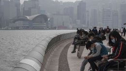 Mask-wearing people in February 2020 sitting at the Tsim Sha Tsui Promenade in Hong Kong amid the Wuhan coronavirus outbreak. Credit: Matt Leung/iStock.